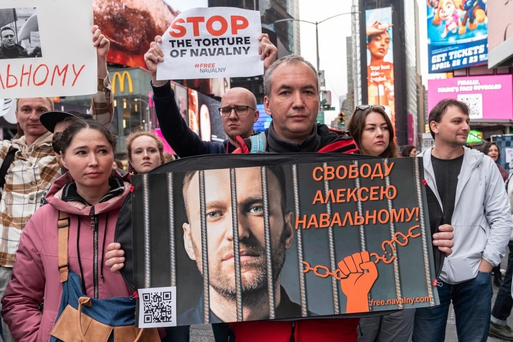 Protestors demanding action to free Russian political prisoners hold up a sign of Alexei Navalny