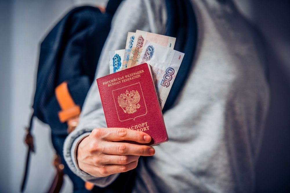 Tourist holds Russian passport and Russian roubles