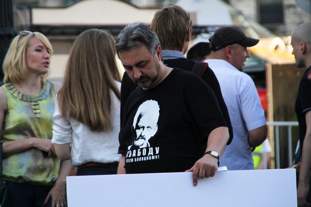 Man holding sign with shirt supporting Ales Bialiatski