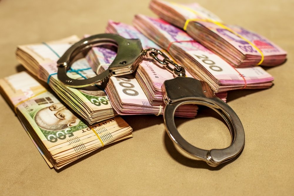 Iimage of Ukrainian hryvnia and handcuffs