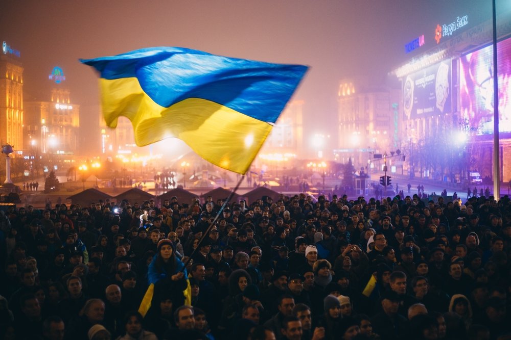 Meeting on the Independence square at night in Kiev. Girl holding a flag of Ukraine. During revolution to support the integration of Ukraine into the European Union.