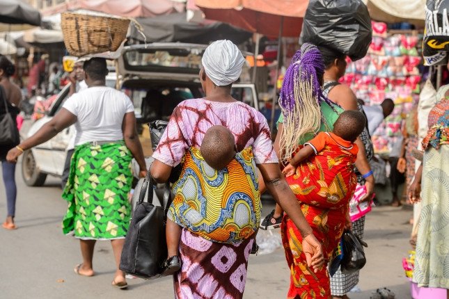 Little babies carried by their mothers at a market in West Africa.