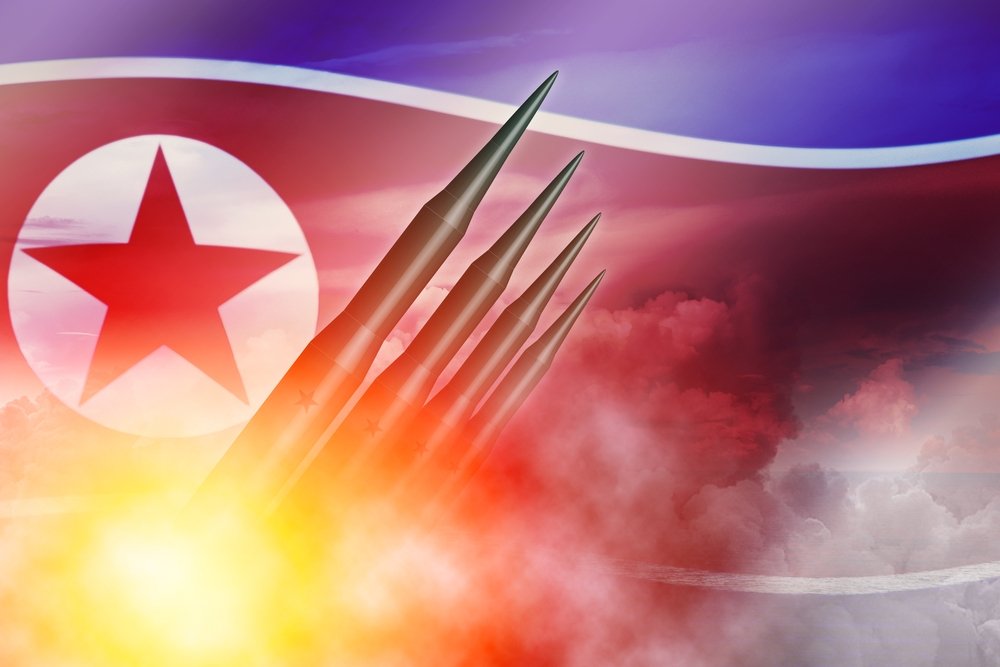 Missiles being launched over a North Korean flag