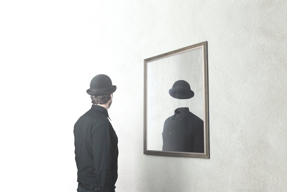 identity absence surreal concept; man in front of mirror reflecting himself without face