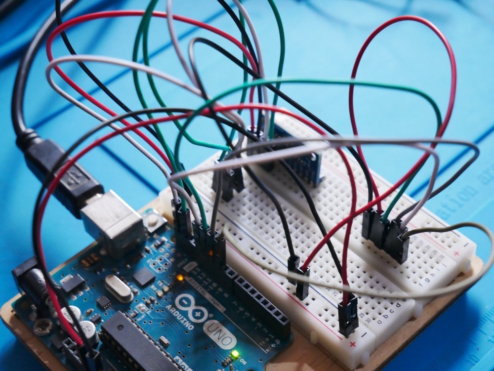 a close up of a board with wires attached to it An Arduino Uno board wired to a couple of sensors on a breadboard.