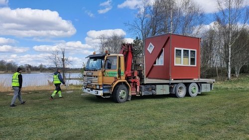 A folding house arrives on a flat-bed truck