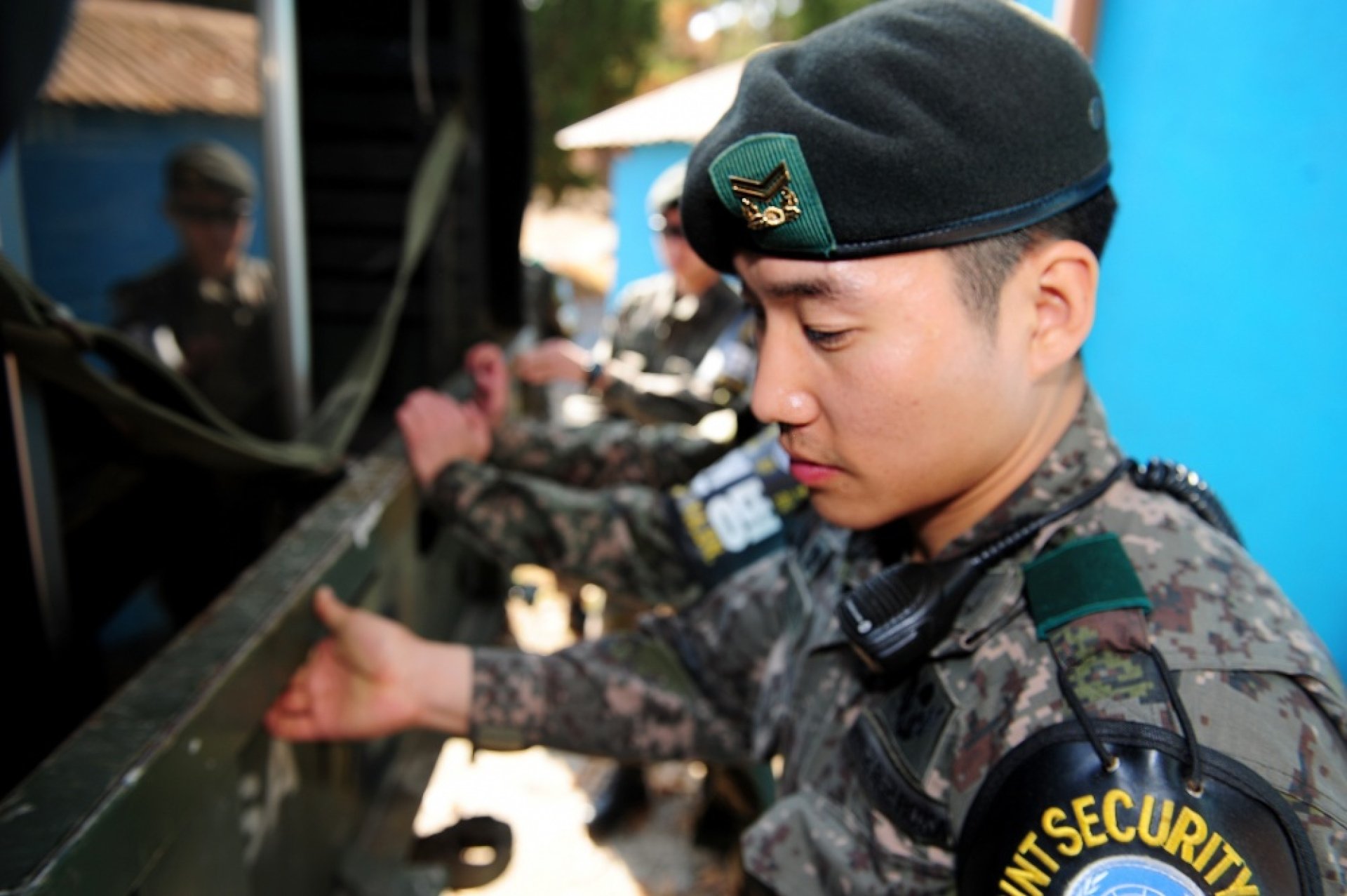 A soldier stands at the back of a transport truck.