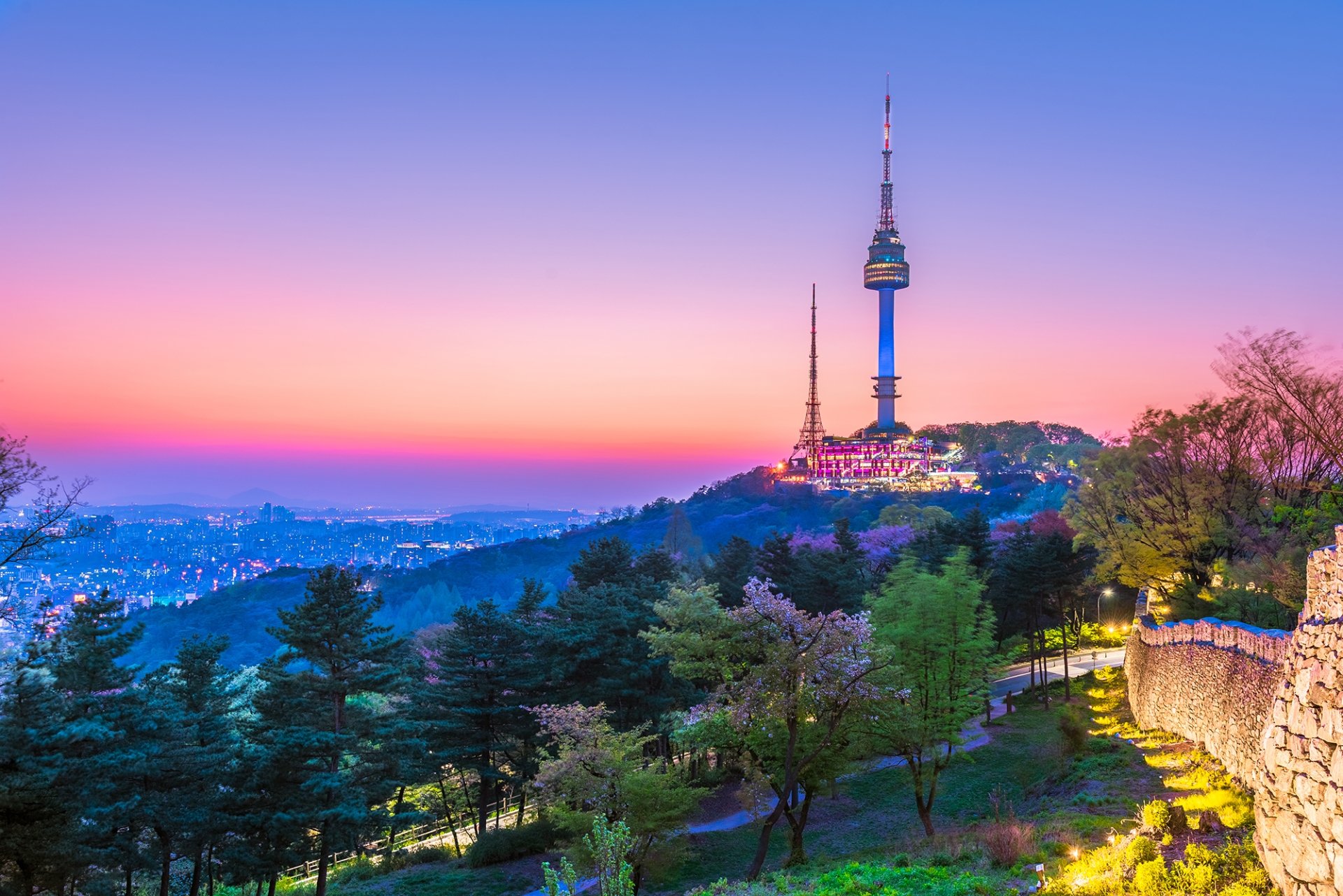 Two communication towers on the top of a hill at sunset