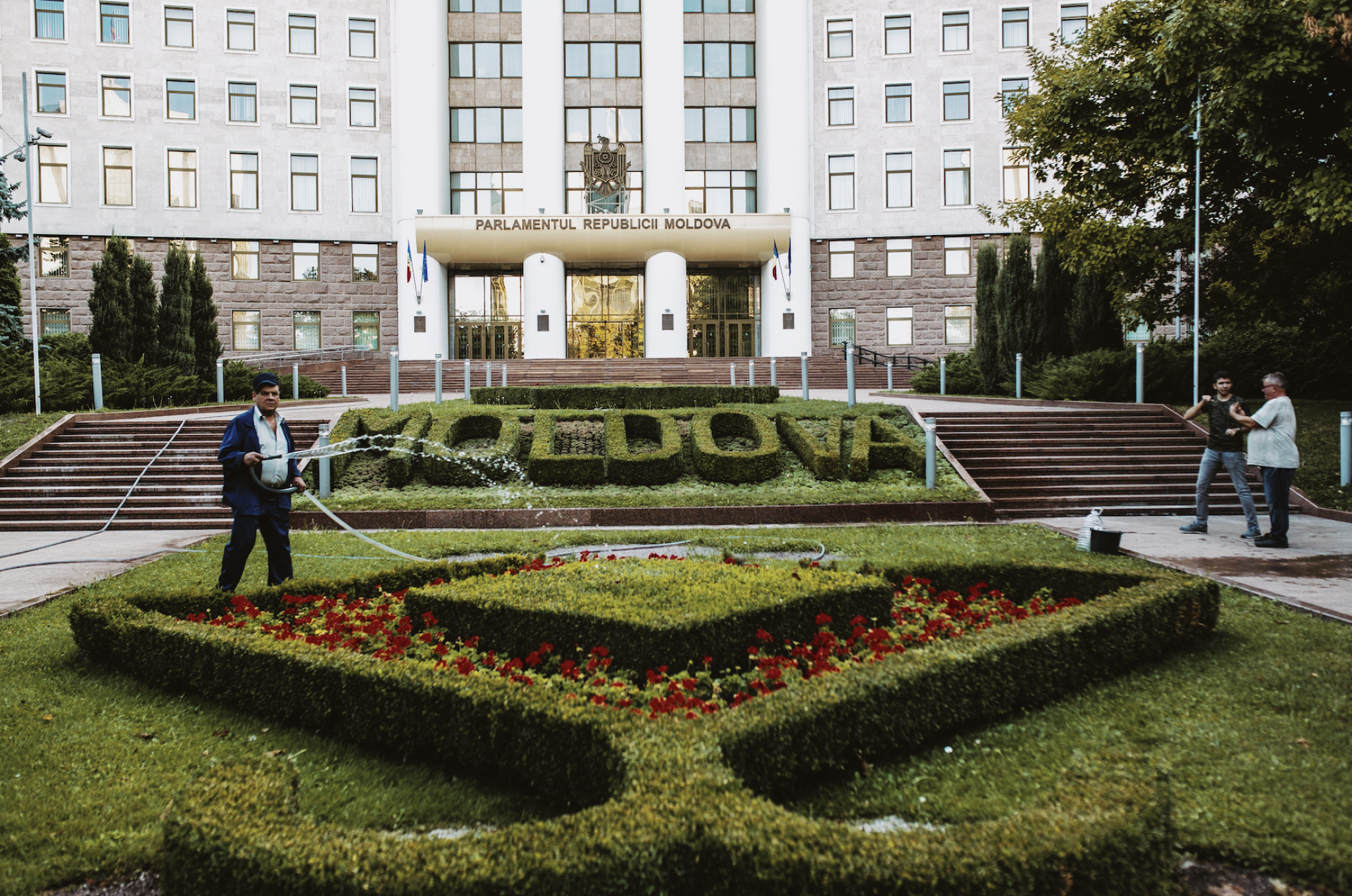 Image - Ukrainian man watering garden in front of Moldova's parliament