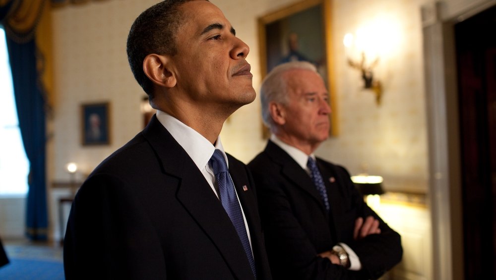 President Obama and Joe Biden stand next to each other in the Oval Office.