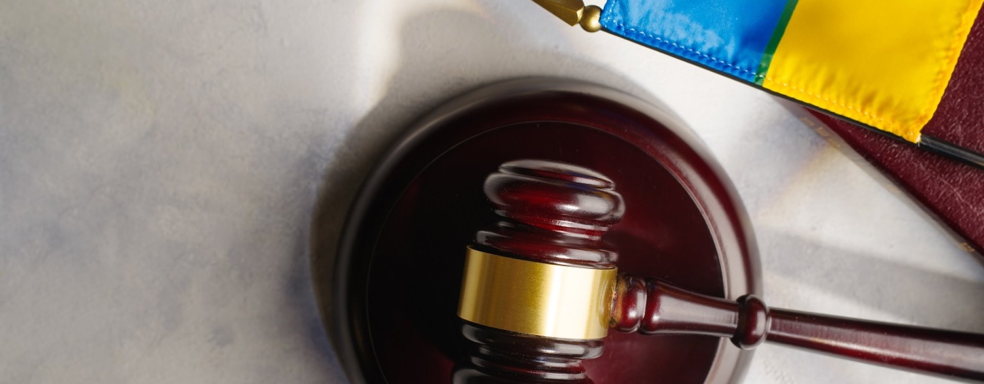 A gavel on a desk next to a Ukrainian flag