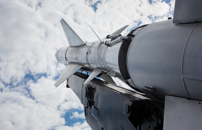 A military rocket pointed into a cloudy sky
