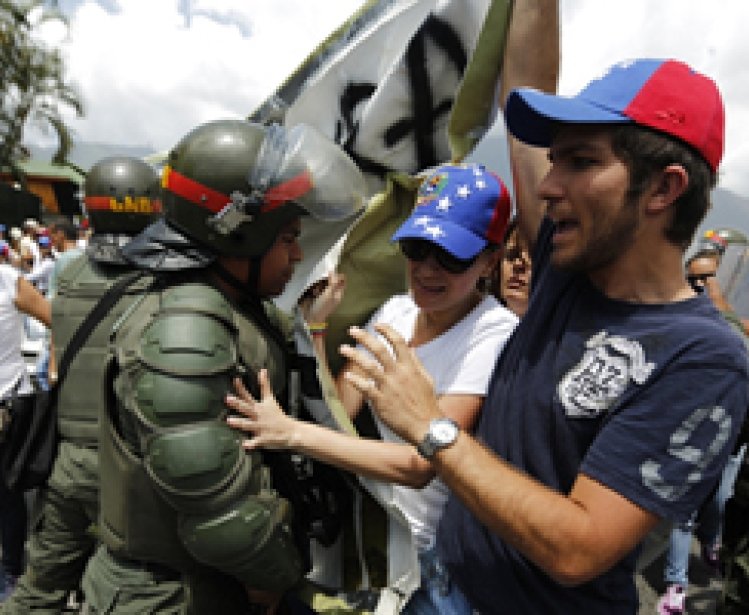 Anti-government protesters scuffle with national guards as they march by Generalisimo Francisco de Miranda Airbase in Caracas March 4, 2014. 