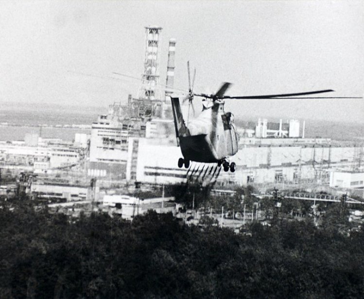 Image: A helicopter sprays a decontamination liquid nearby the Chernobyl reactor in 1986. Source: IAEA Imagebank #02790036, via Wikimedia Commons, CC BY-SA 2.0.