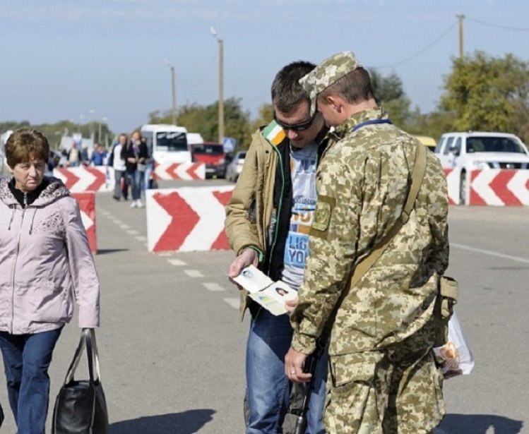 Border guard checking traveler’s passport at the border crossing point Kalanchak. September 20, 2017. Khersonskaya oblast, Ukraine. Source: Shutterstock.