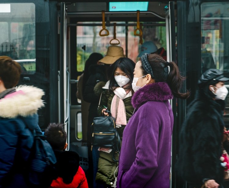 People riding a train in Chengdu, China wearing masks.