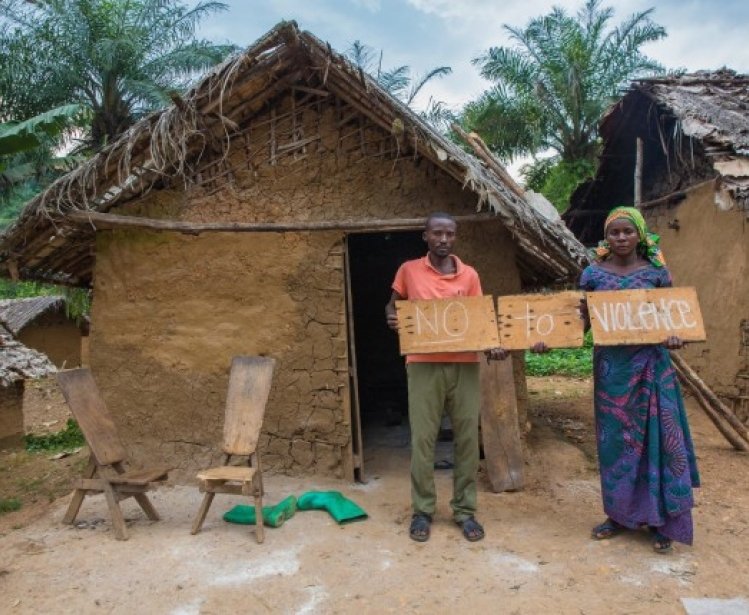 A husband and wife in the Democratic Republic of Congo hold signs up in opposition to sexual and gender-based violence