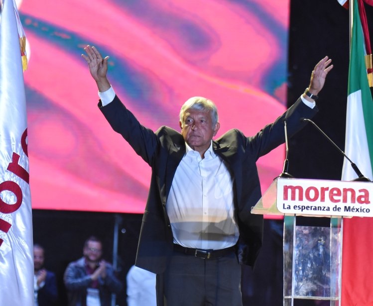 AMLO with his hands up at a Morena rally