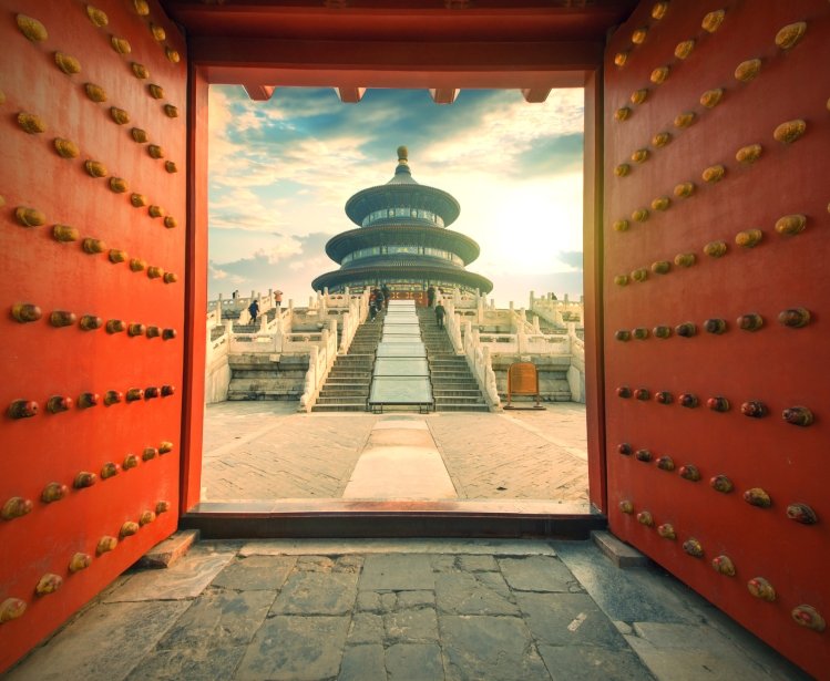 A view of a Chinese temple through a red door
