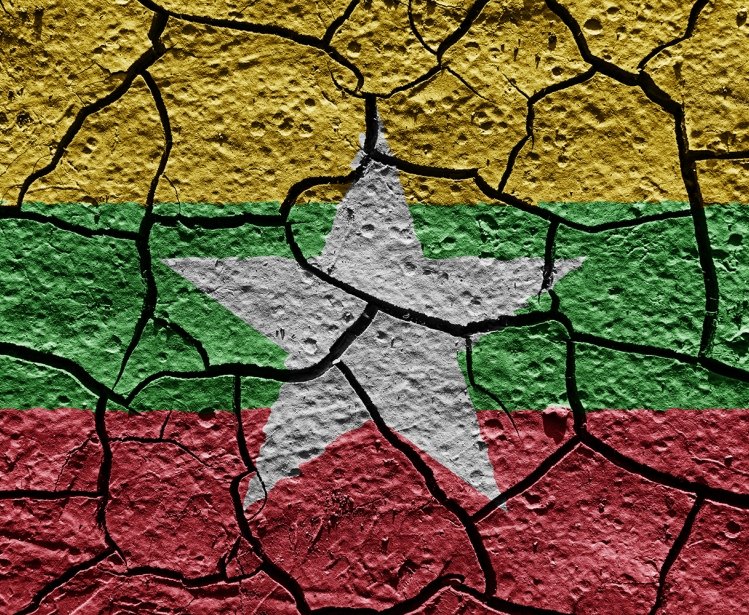The flag of Myanmar painted on cracked pavement