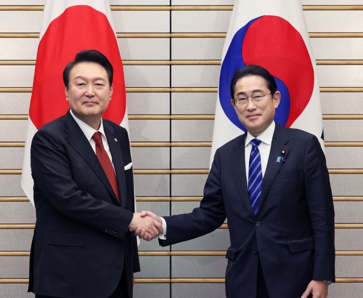South Korean President Yoon and Japanese Prime Minister Kishida shaking hands in a photo op.