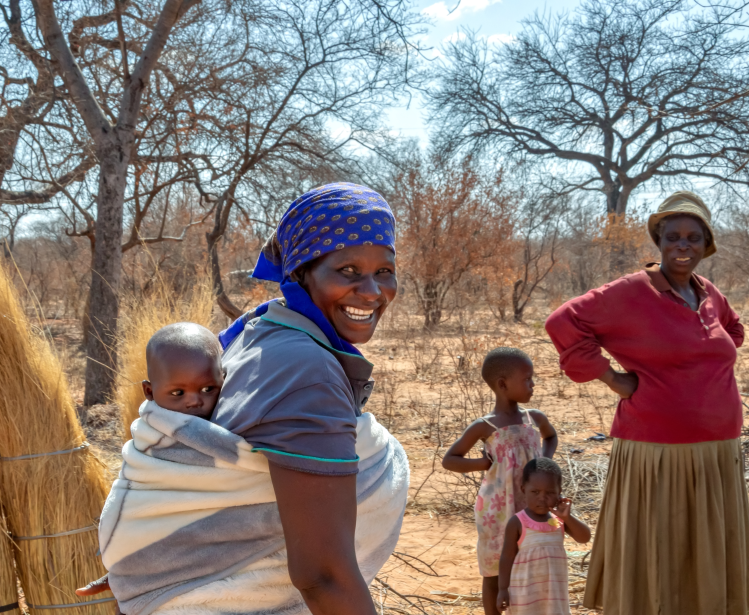 african woman carry child in the back in a traditional way in a blanket