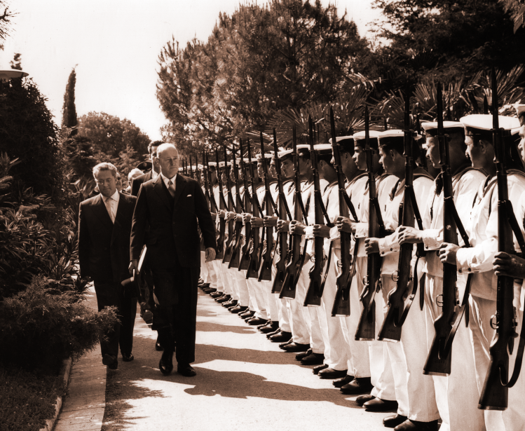 George F. Kennan stands before a line of soldiers