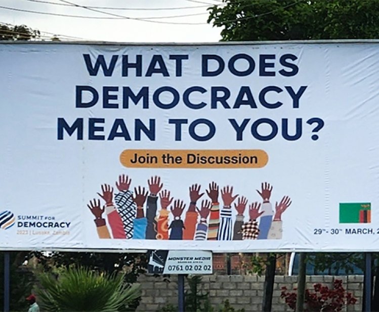 Billboard displaying "What does democracy mean to you"? for the 2023 Summit for Democracy