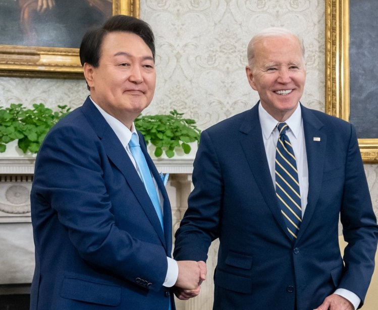 President Yoon shakes hands with President Biden in the Oval Office.