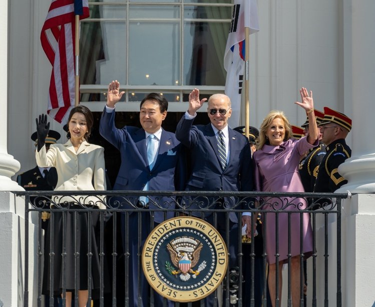 Presidents Yoon and Biden with their wives waving from the balcony at the White House