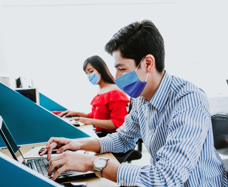 Workers with face masks at computers.