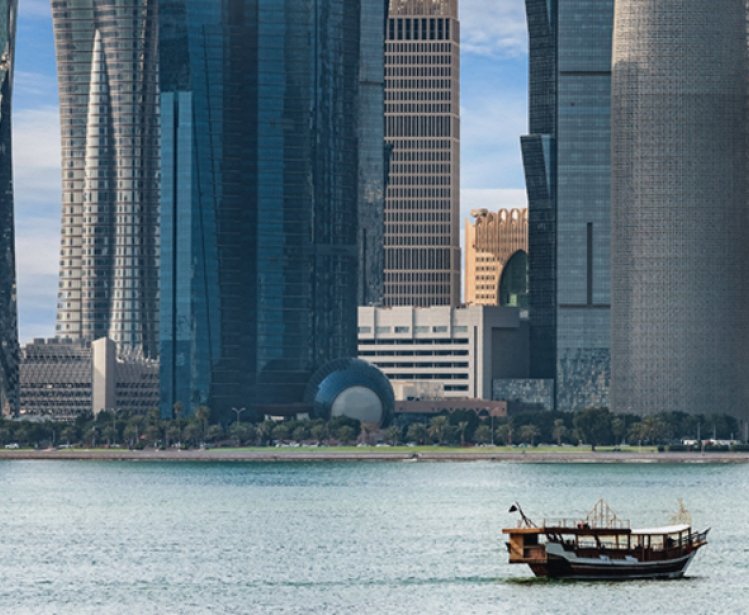 Boat in the water in front of large modern highrises