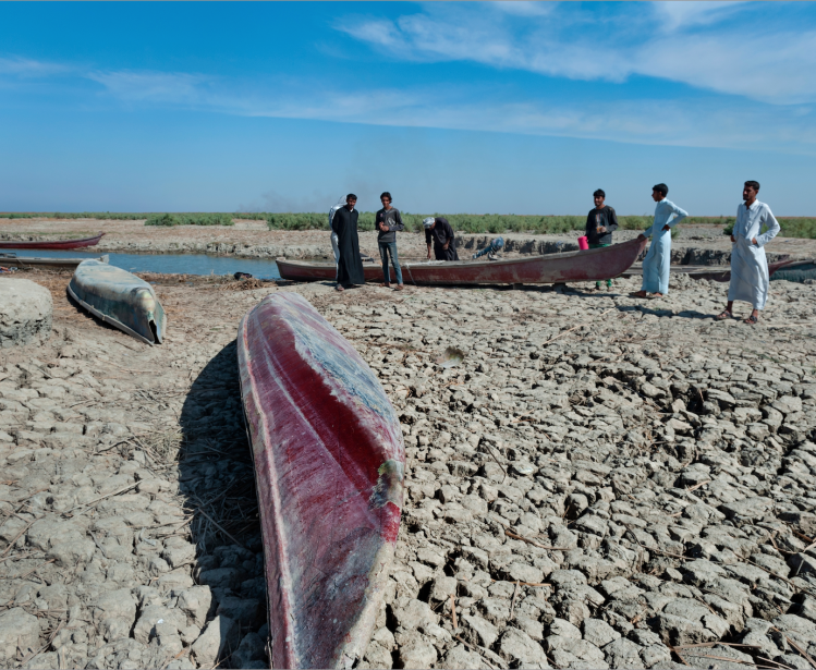 Boats on dried cracked earth during a drought in the Southern Marshes of Iraq.