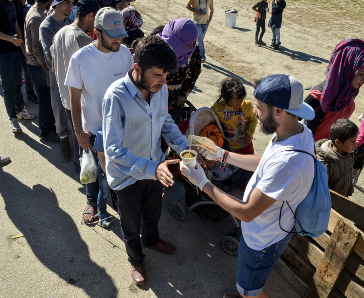 Refugees waiting in line for food.