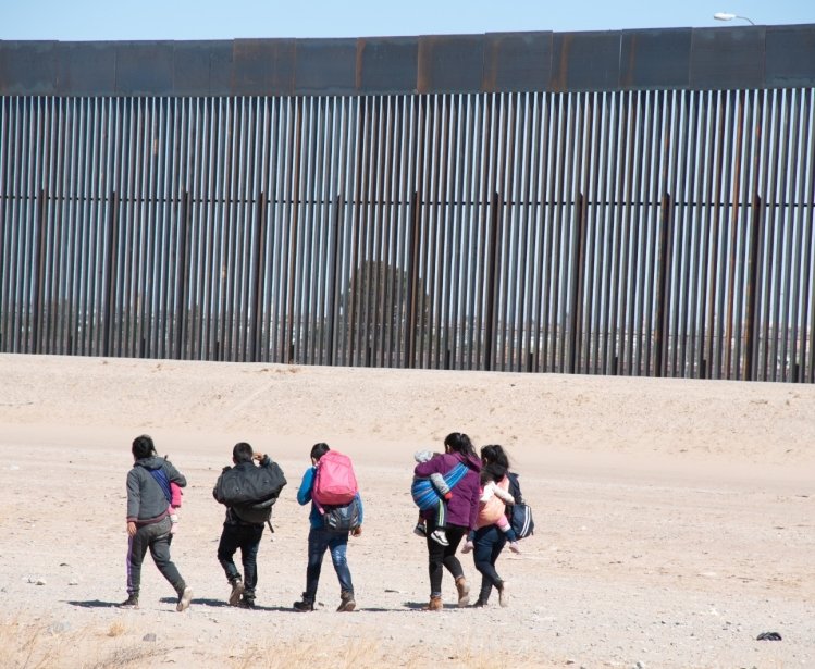 A group of migrants walks near the U.S. border.