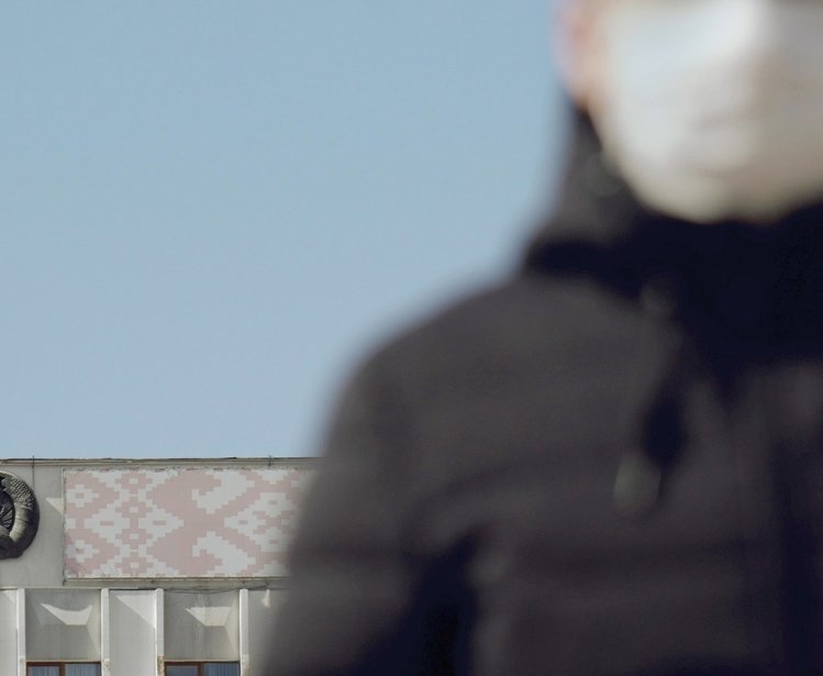 Man with mask in front of Belarus flag