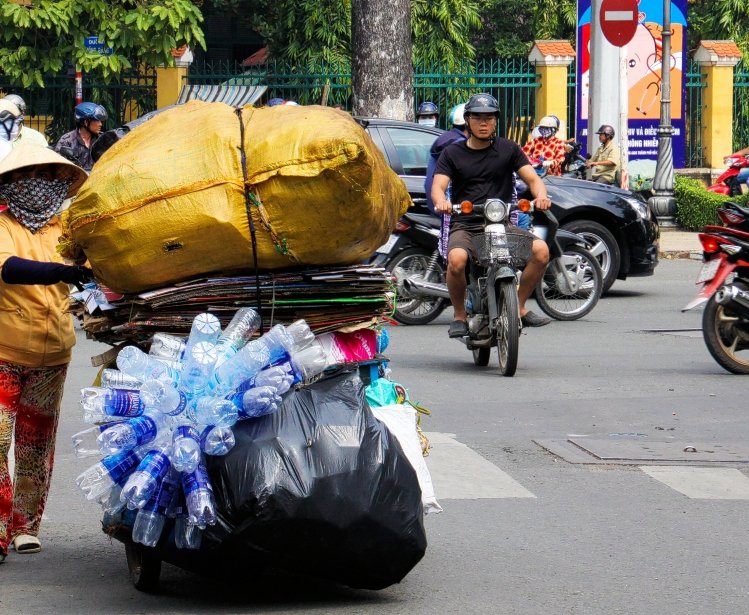  Overloaded motorbike with collected plastic bottles in traffic of Saigon