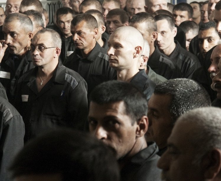 Large group of men in prisoner clothing 