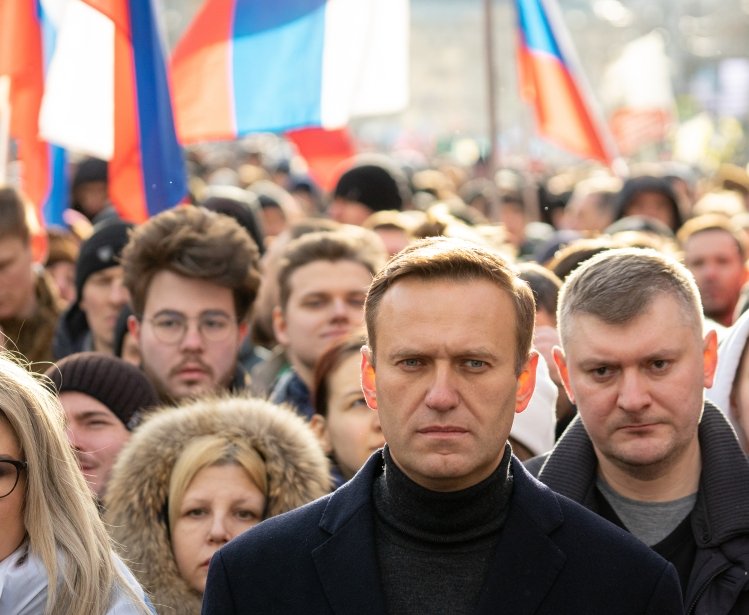 Lyubov Sobol abd Alexei Navalny on march in memory of Boris Nemtsov. People, flag and poster on the background, February 2020.
