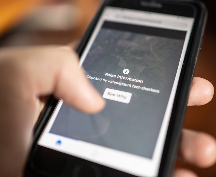 A phone displays a warning about false information.