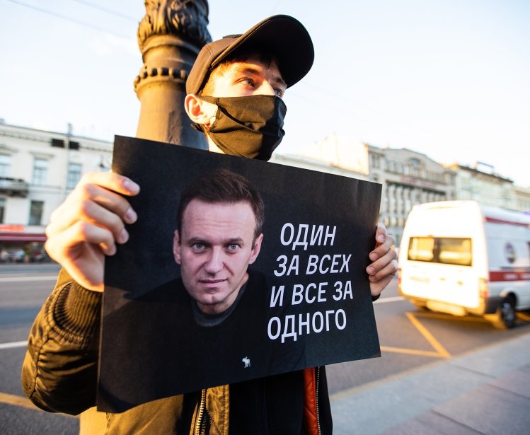Person pickets in support of Alexei Navalny following his August 2020 poisoning. Sign reads "One for all and all for one"