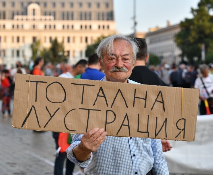 Man holding protest sign in Sofia, Bulgaria