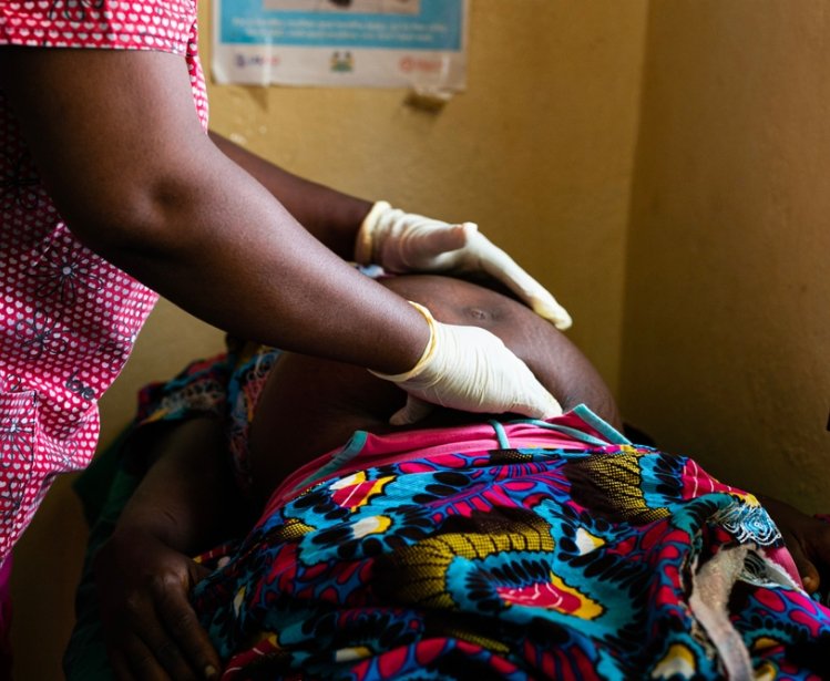 African woman doctor examining a pregnant patient