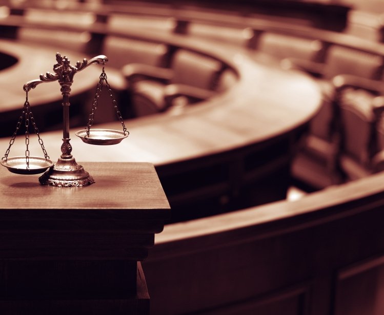 Image of a scale representing justice in front of a court room