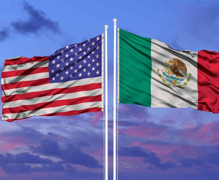 U.S. and Mexican flags at sunset