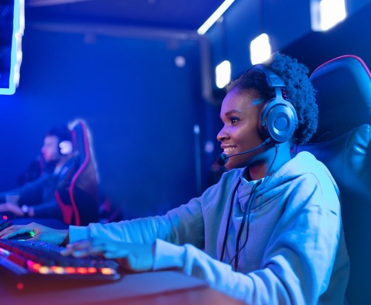 Portrait Streamer African young woman professional gamer playing online games computer, neon color.