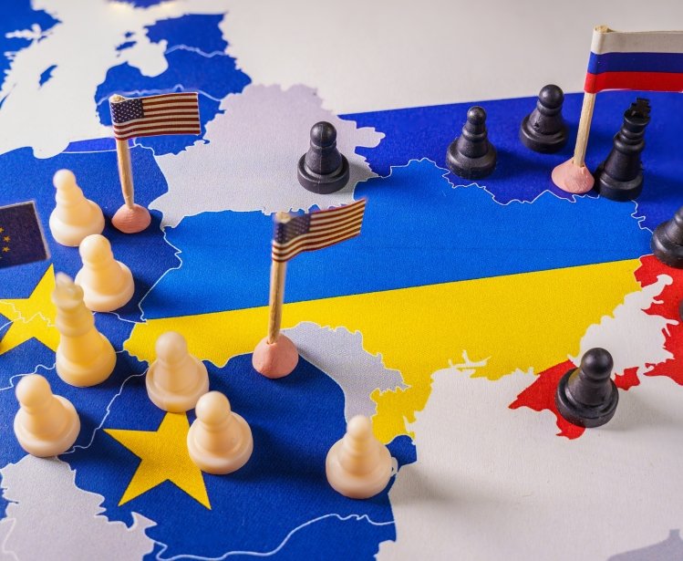 EU, USA and Russian flags with chess pieces symbolizing the conflict and control of Ukraine