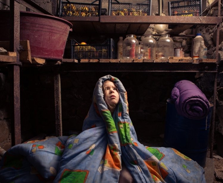 Ukrainian child takes shelter in her basement