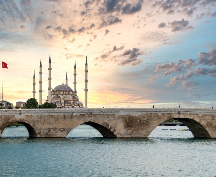 Sabanci Central Mosque and Stone bridge in Adana, Turkey, and the view of Seyhan river with sunset sky. Landmarks in the city of Adana, Turkey