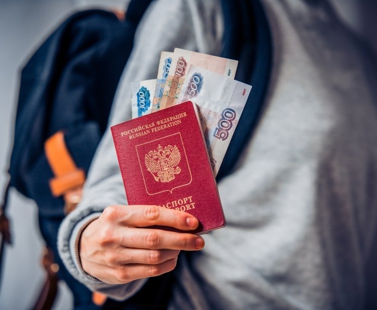 Tourist holds Russian passport and Russian roubles